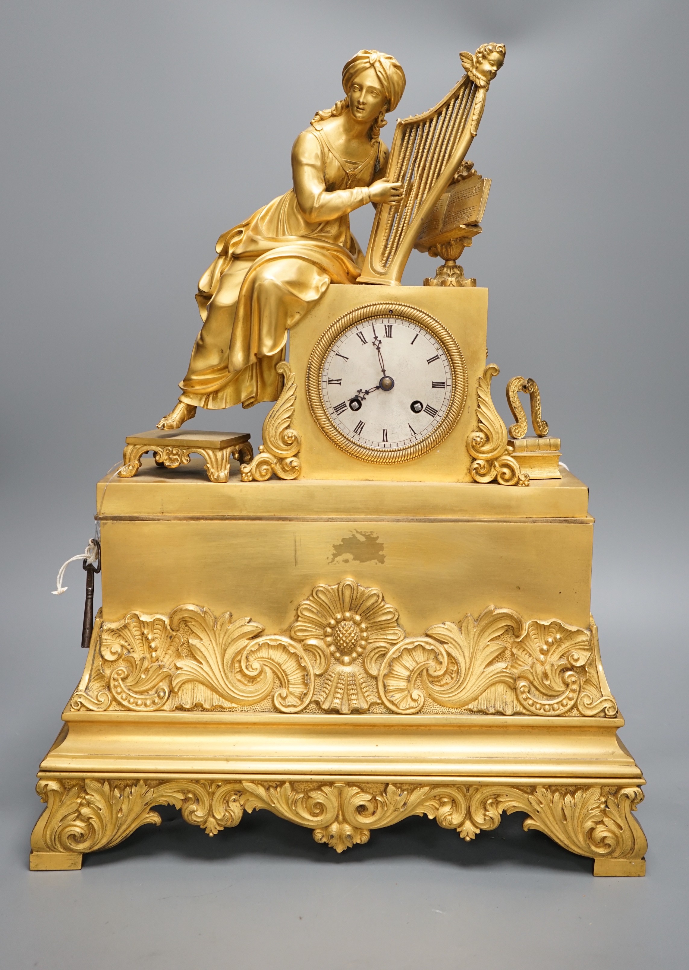 A 19th century French ormolu mounted clock with seated female Harpist decoration, with key, 49cm tall